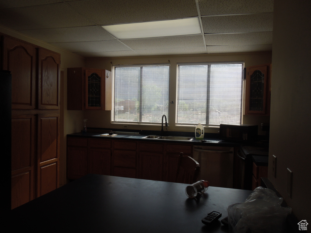 Kitchen with dishwashing machine, black microwave, plenty of natural light, a paneled ceiling, and dark countertops