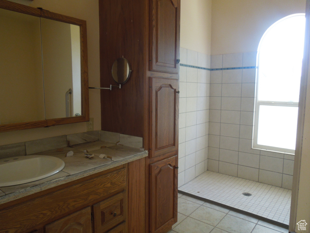 Full bath featuring vanity and tiled shower