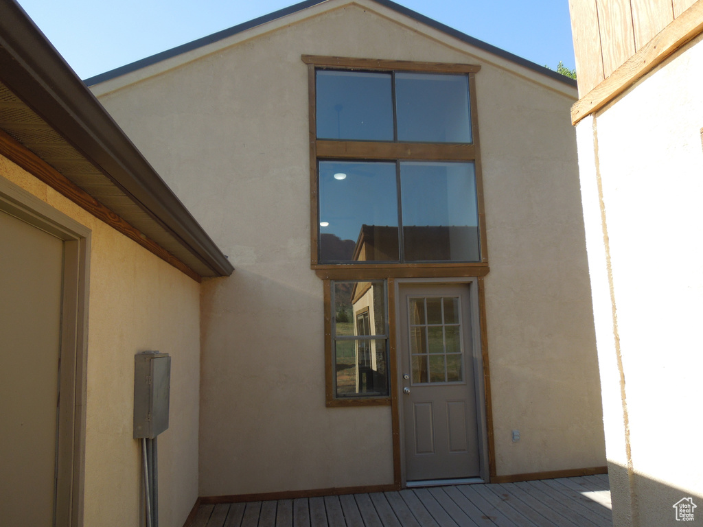 Doorway to property with stucco siding and a deck