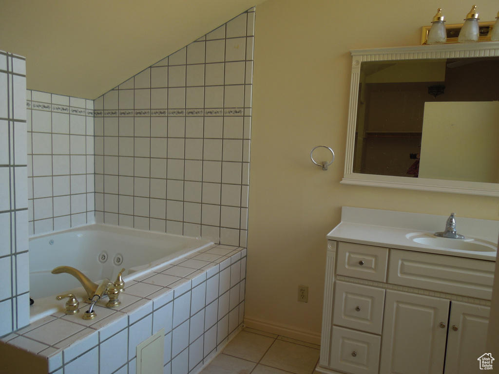 Bathroom with a whirlpool tub, vanity, and tile patterned flooring