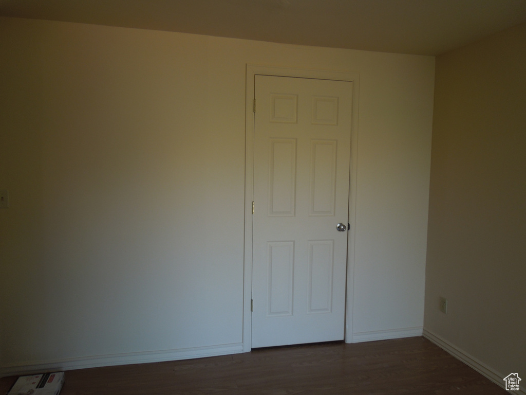 Empty room with dark wood-style floors and baseboards