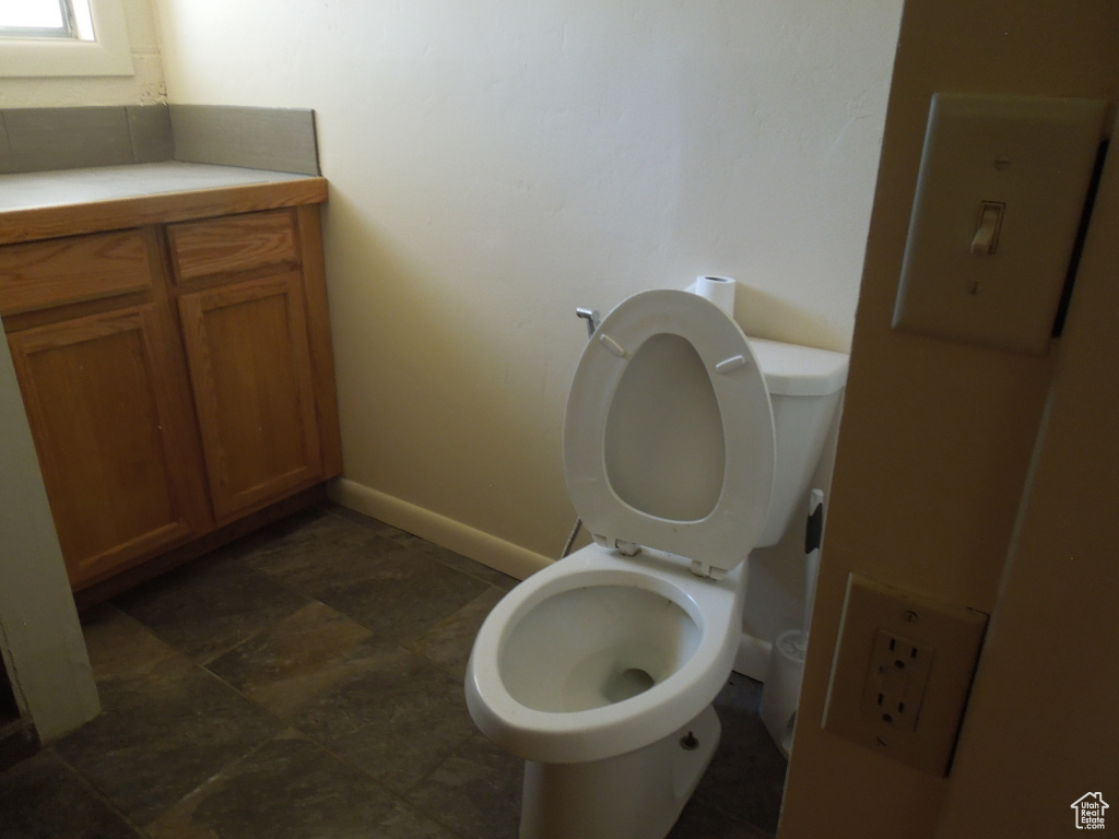 Bathroom with baseboards and stone finish floors