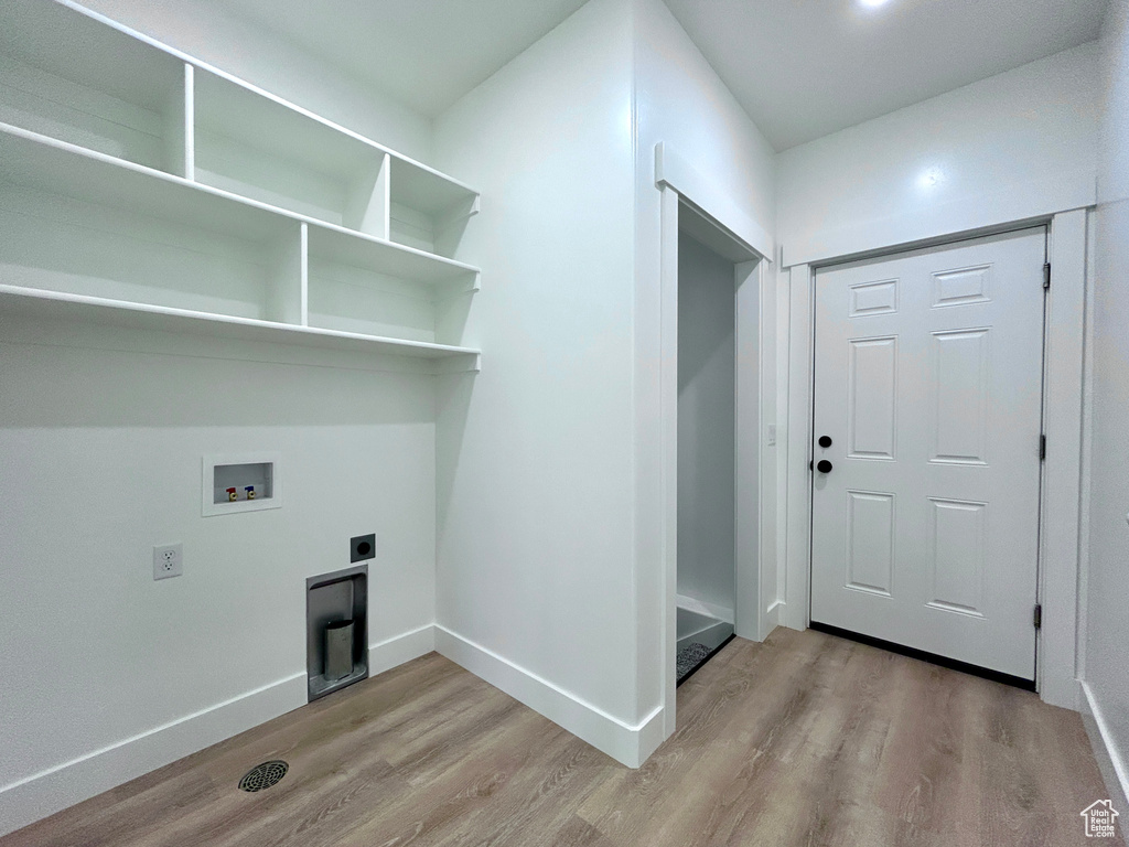 Laundry area with hookup for an electric dryer, wood finished floors, and hookup for a washing machine