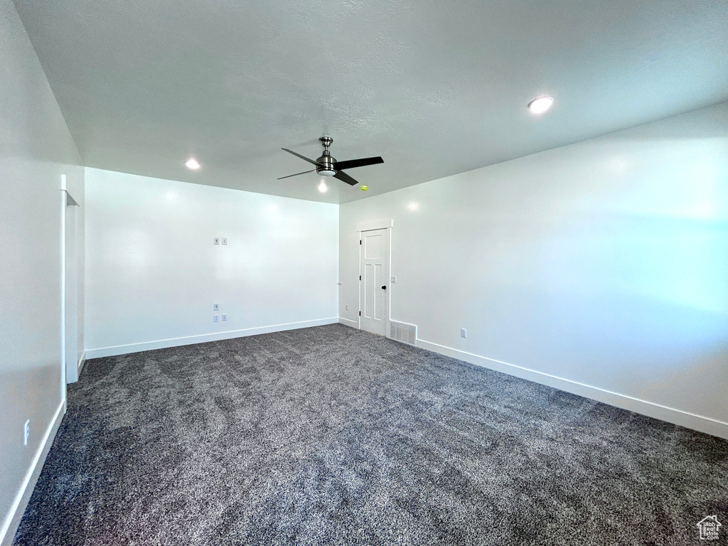 Unfurnished room with dark colored carpet, ceiling fan, and recessed lighting