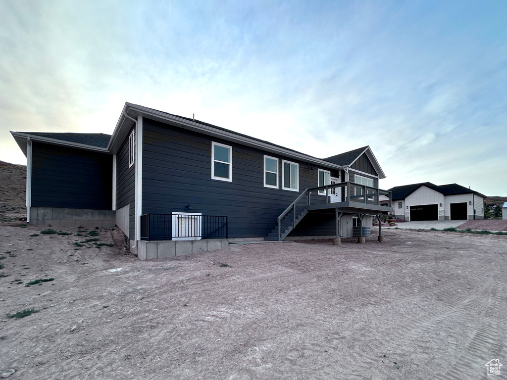 Back of property with stairs and a wooden deck