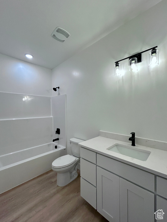 Full bathroom with vanity, wood finished floors, and shower / washtub combination
