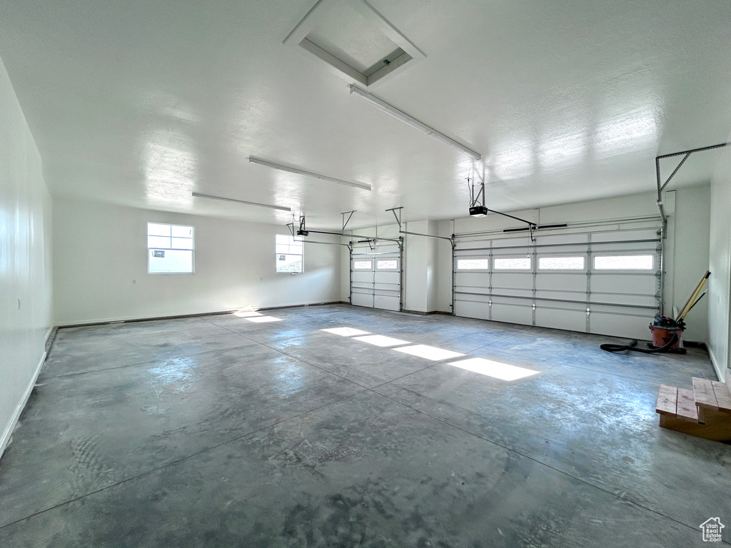 Garage featuring baseboards and a garage door opener