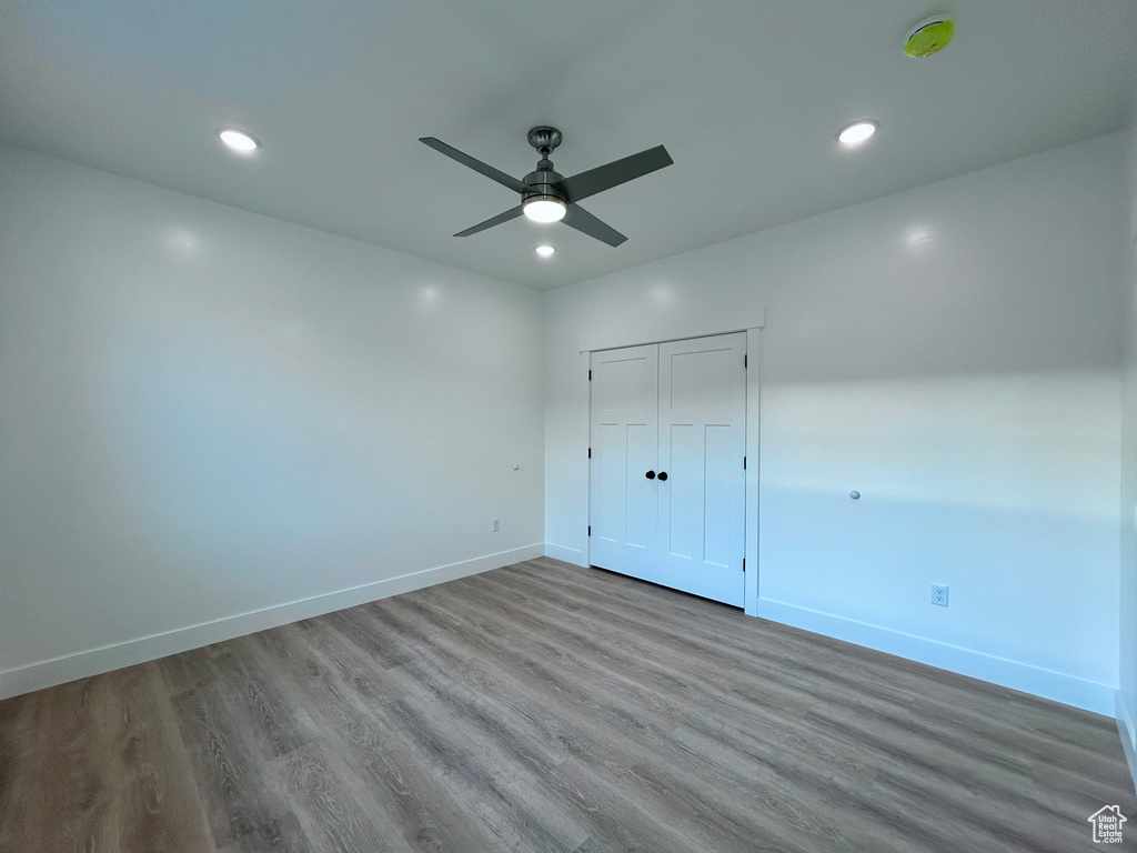 Unfurnished bedroom with wood finished floors, recessed lighting, a ceiling fan, and a closet