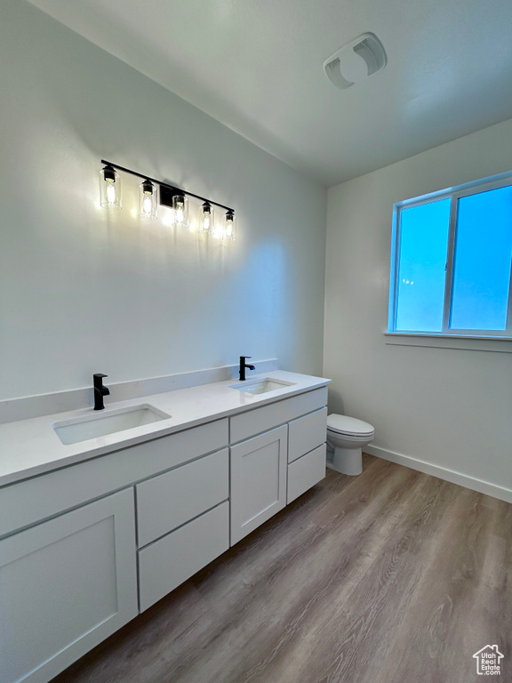 Bathroom featuring double vanity and wood finished floors