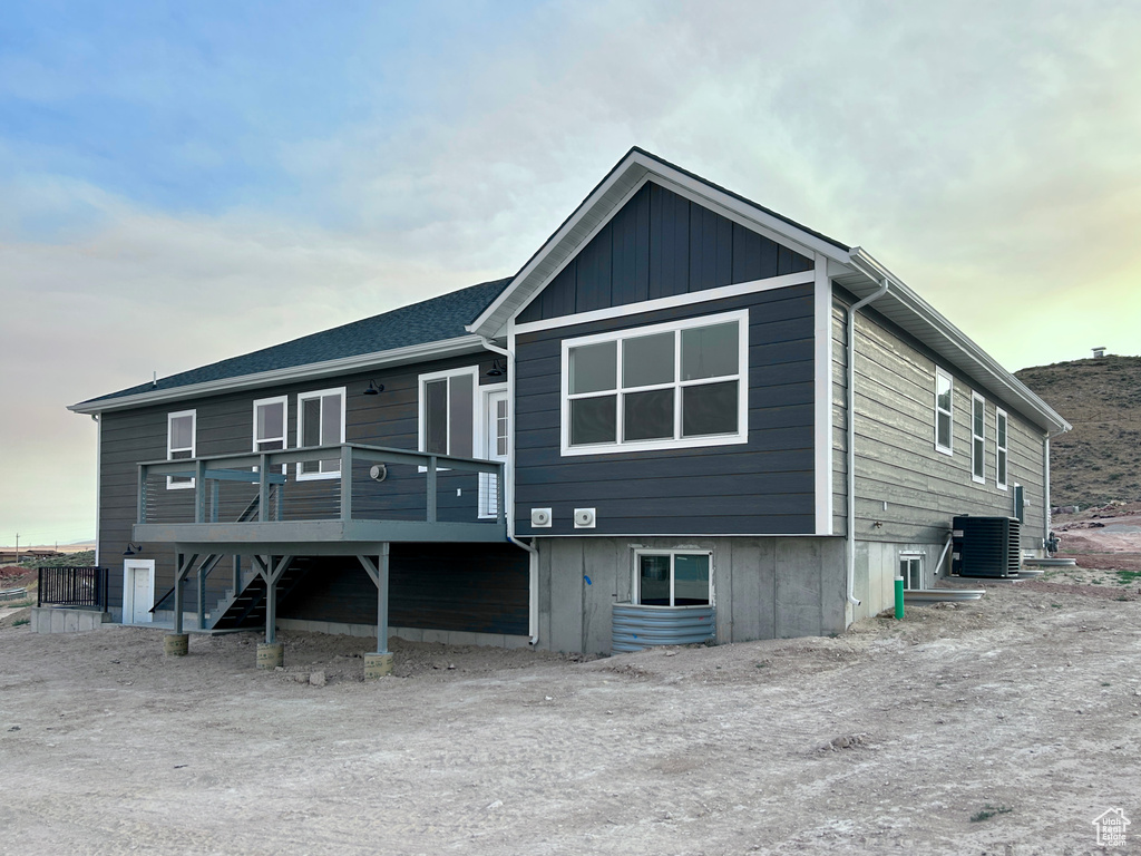 Rear view of house featuring a wooden deck and stairway