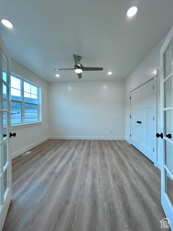 Unfurnished bedroom with wood finished floors, recessed lighting, french doors, and ceiling fan