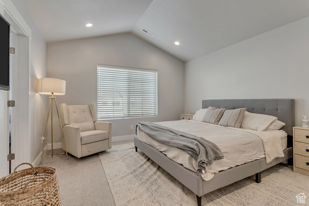 Bedroom with light colored carpet, vaulted ceiling, and recessed lighting