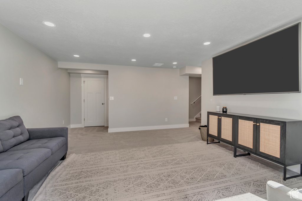 Living area with recessed lighting, stairway, and light colored carpet