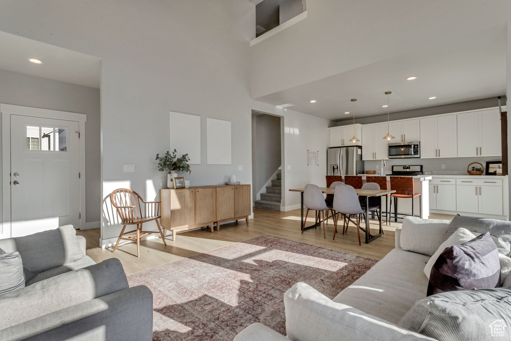Living room featuring light wood-style floors, stairs, and recessed lighting