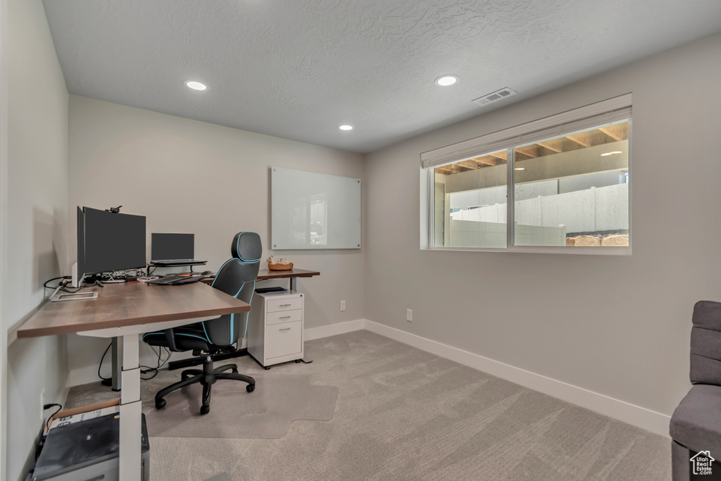 Home office featuring light carpet, recessed lighting, and a textured ceiling