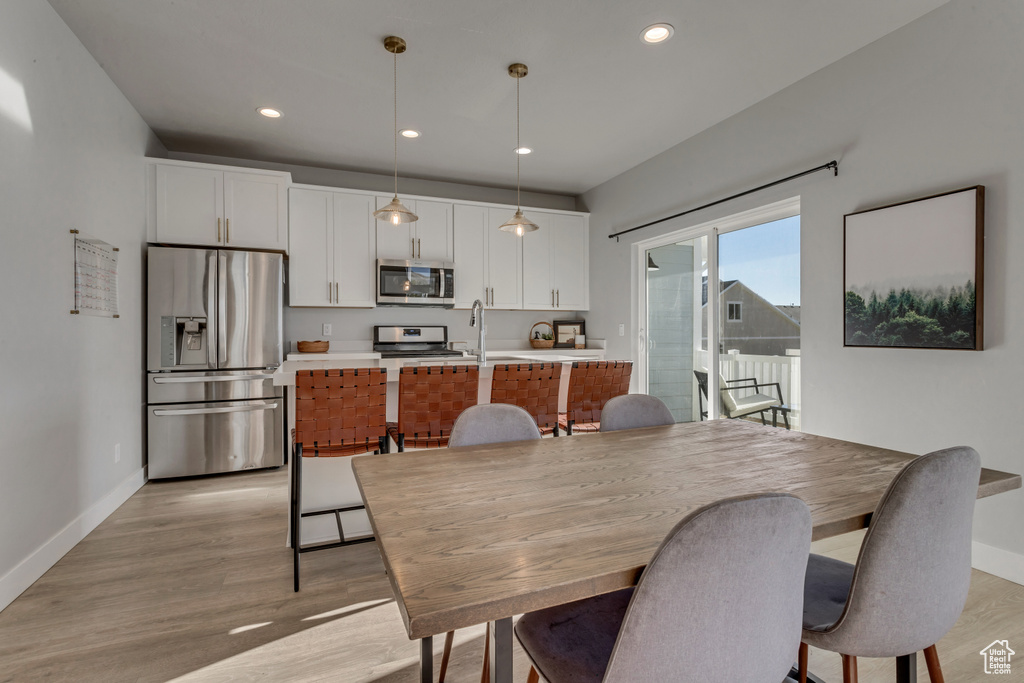 Dining area with light wood-type flooring and recessed lighting