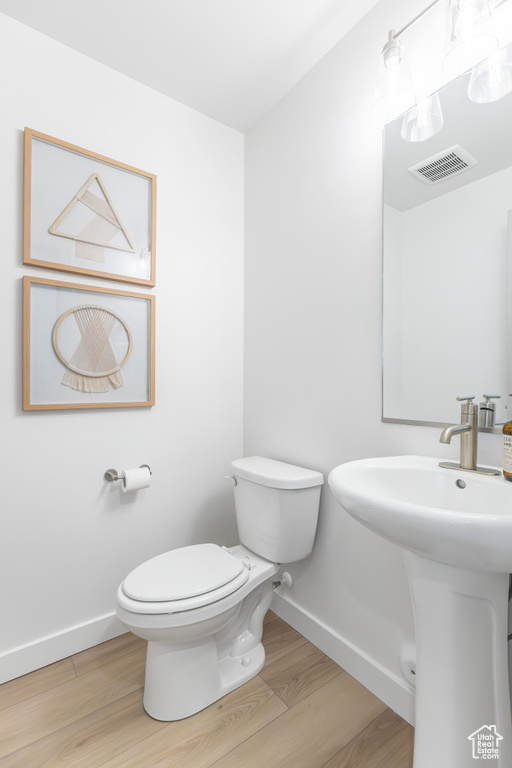 Bathroom with toilet and wood finished floors