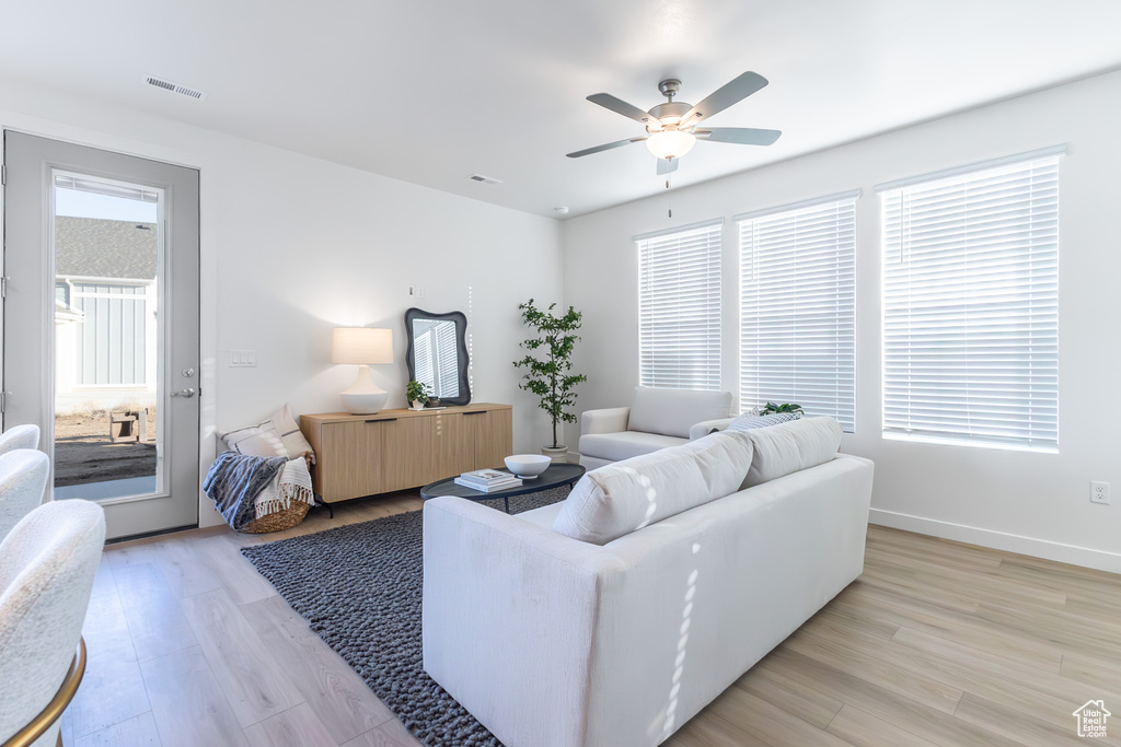 Living room with light wood finished floors and ceiling fan