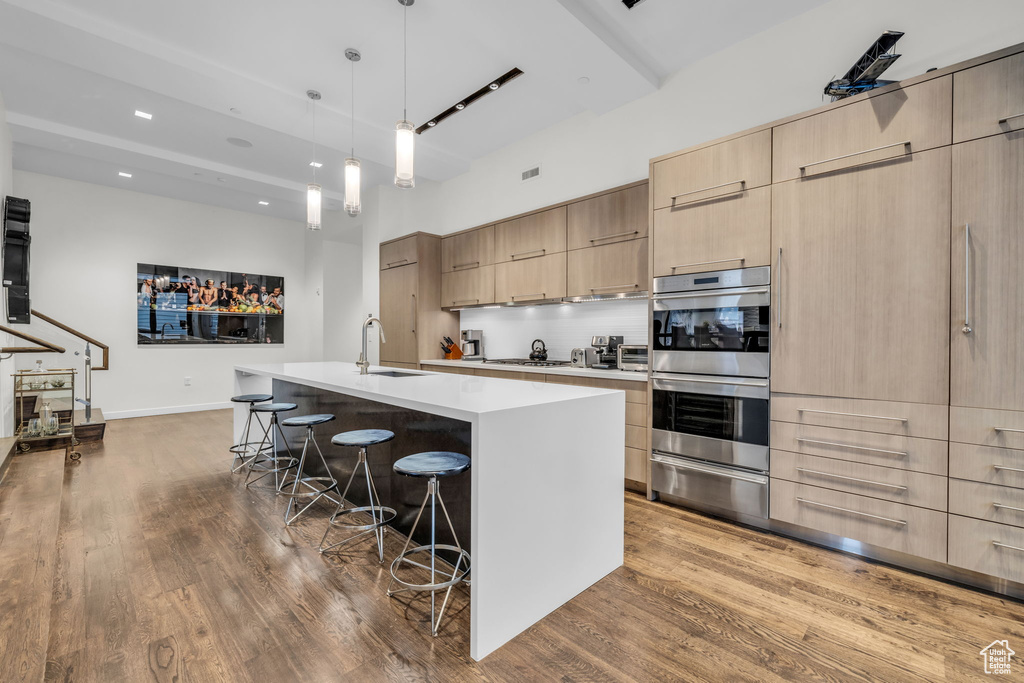 Kitchen featuring a warming drawer, light brown cabinets, modern cabinets, appliances with stainless steel finishes, and recessed lighting