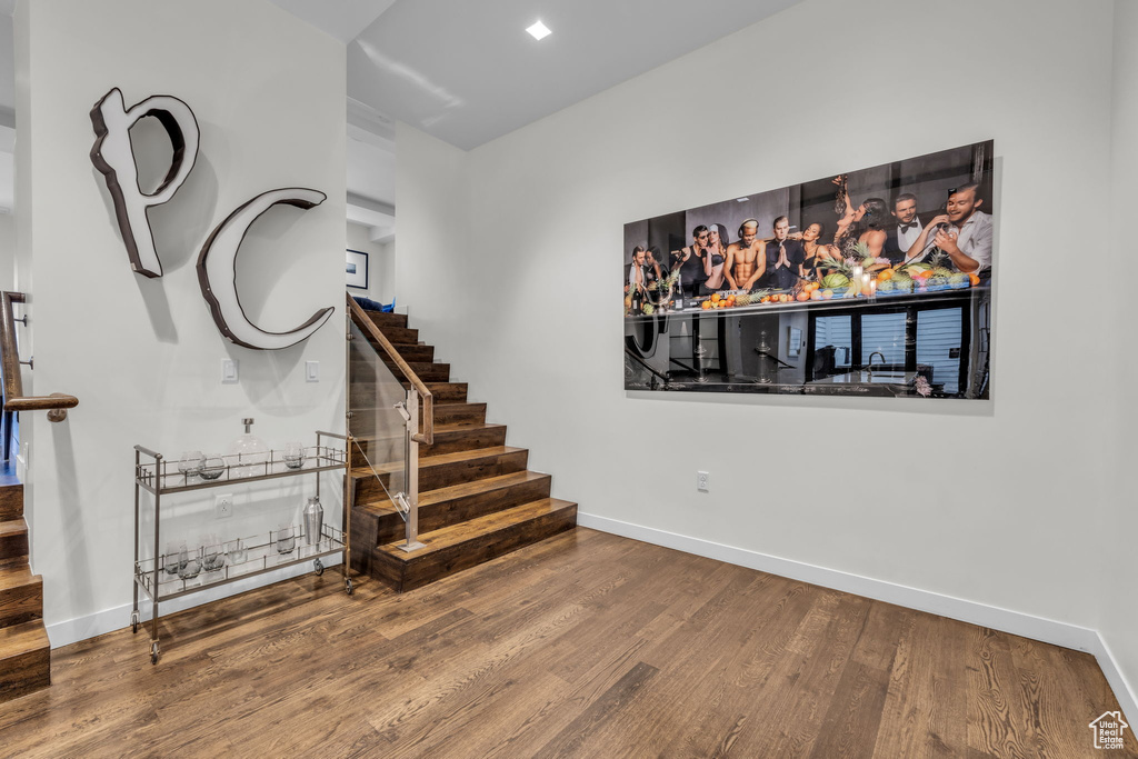 Staircase with wood finished floors and baseboards