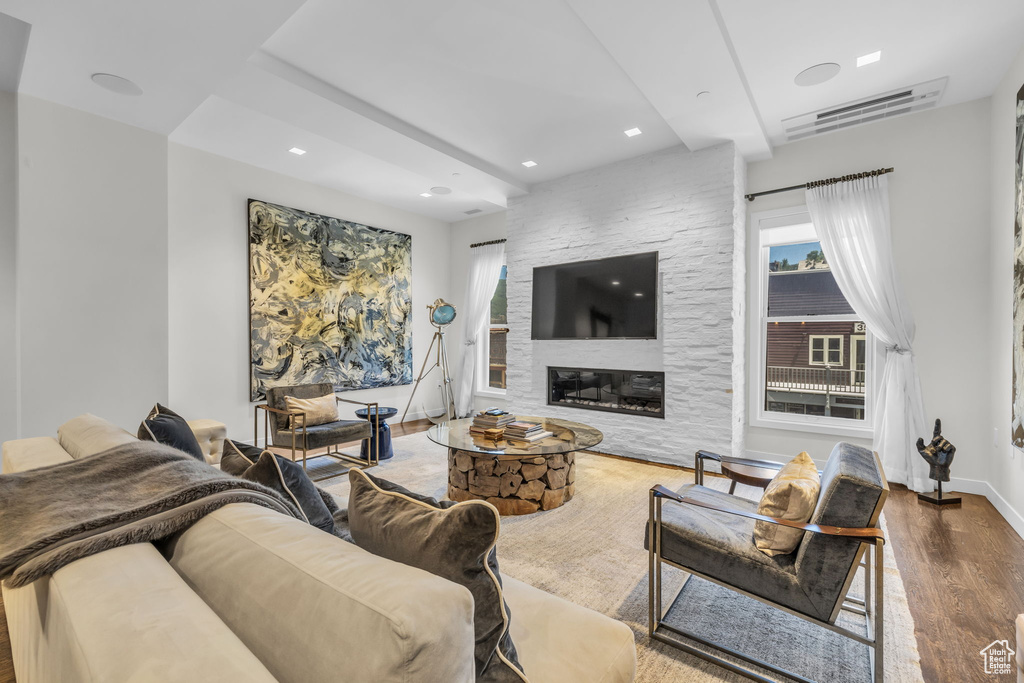 Living room featuring wood finished floors, a large fireplace, and recessed lighting