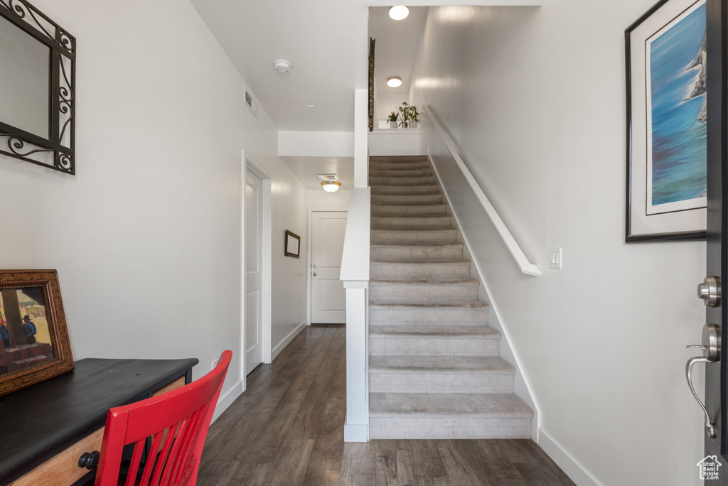 Stairs with wood finished floors and baseboards