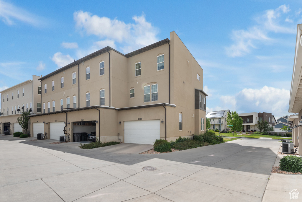 View of building exterior featuring a residential view and an attached garage