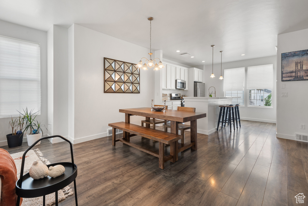 Dining room featuring dark wood finished floors, a chandelier, and recessed lighting