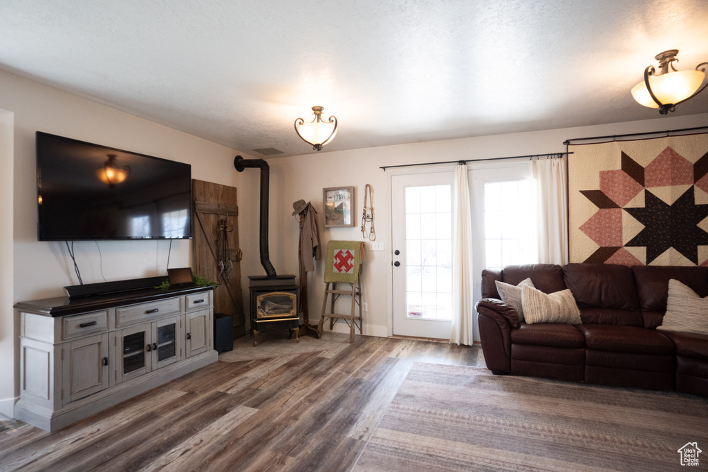 Living room with a wood stove and wood finished floors