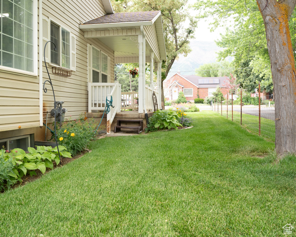 View of green lawn with covered porch