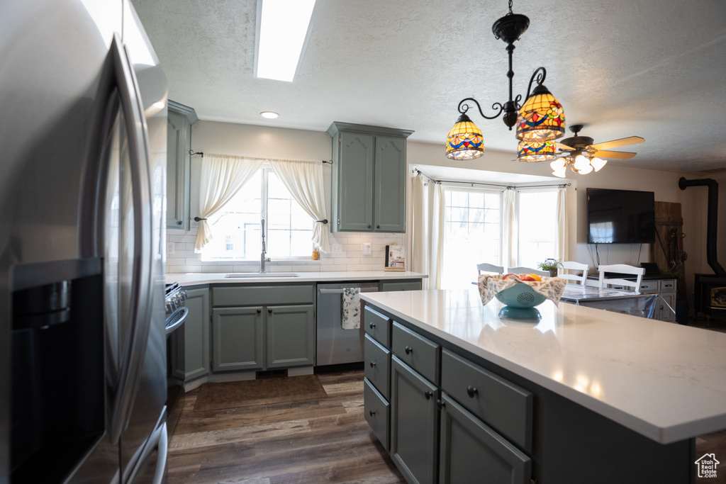 Kitchen featuring stainless steel appliances, gray cabinetry, plenty of natural light, a textured ceiling, and recessed lighting