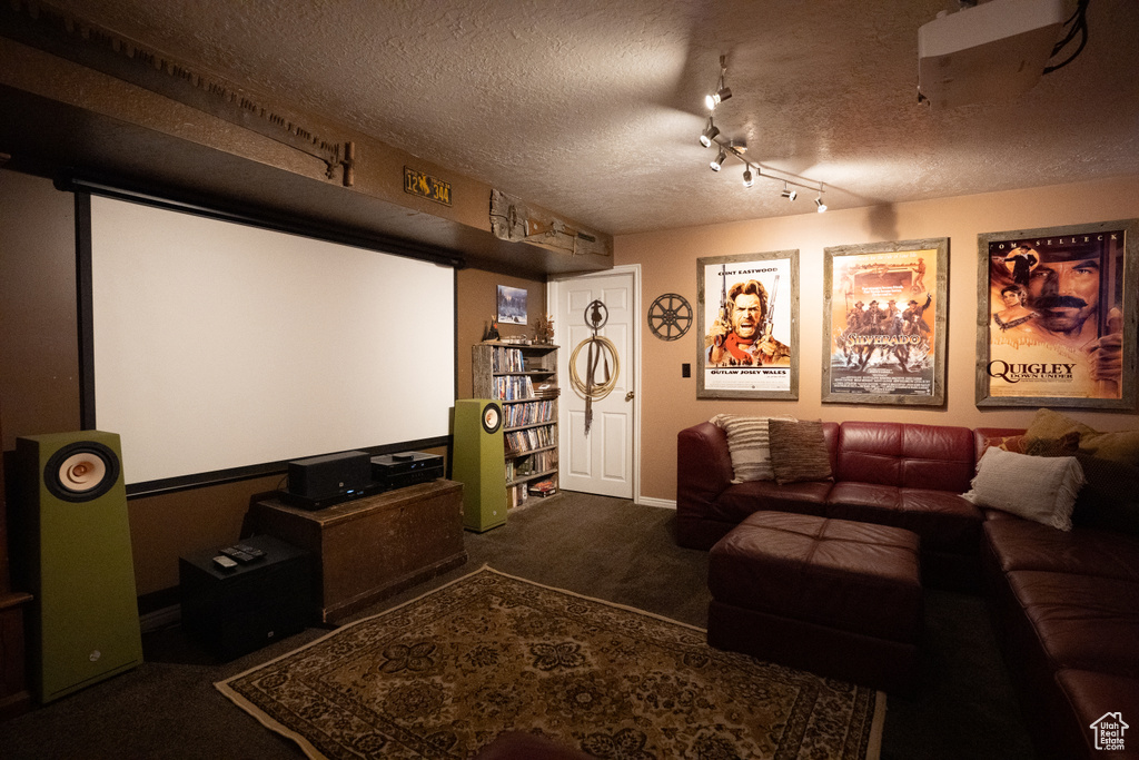 Home theater room featuring carpet and a textured ceiling