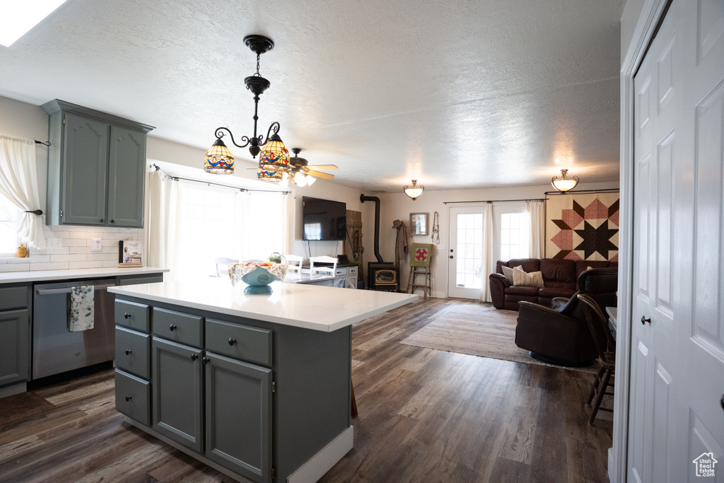 Kitchen featuring stainless steel dishwasher, gray cabinetry, a textured ceiling, light countertops, and decorative backsplash