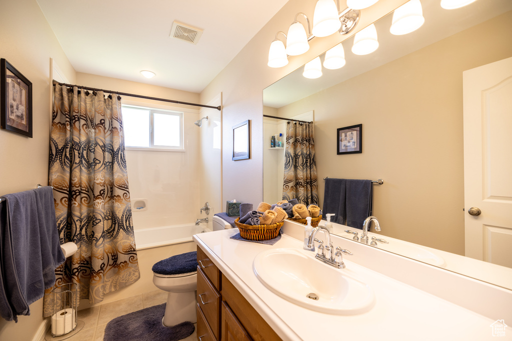 Bathroom featuring vanity, shower / bathtub combination with curtain, and tile patterned floors