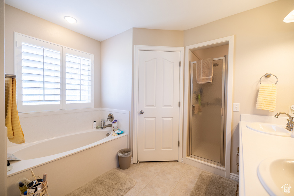 Full bathroom with tile patterned flooring, a shower stall, a bath, and double vanity