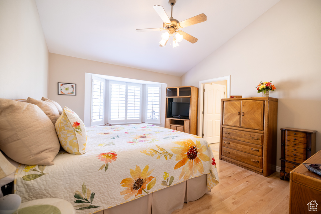 Bedroom featuring light wood-style flooring, lofted ceiling, and ceiling fan