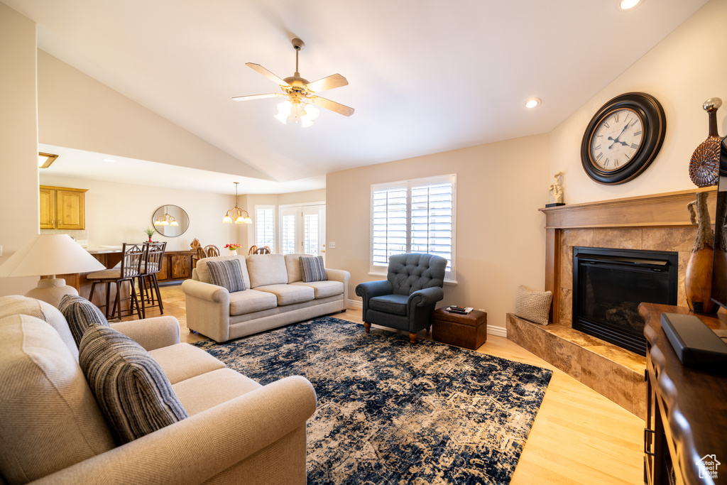 Living area featuring lofted ceiling, a fireplace, wood finished floors, ceiling fan, and recessed lighting