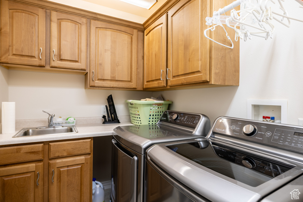 Laundry room with washer and clothes dryer and cabinet space