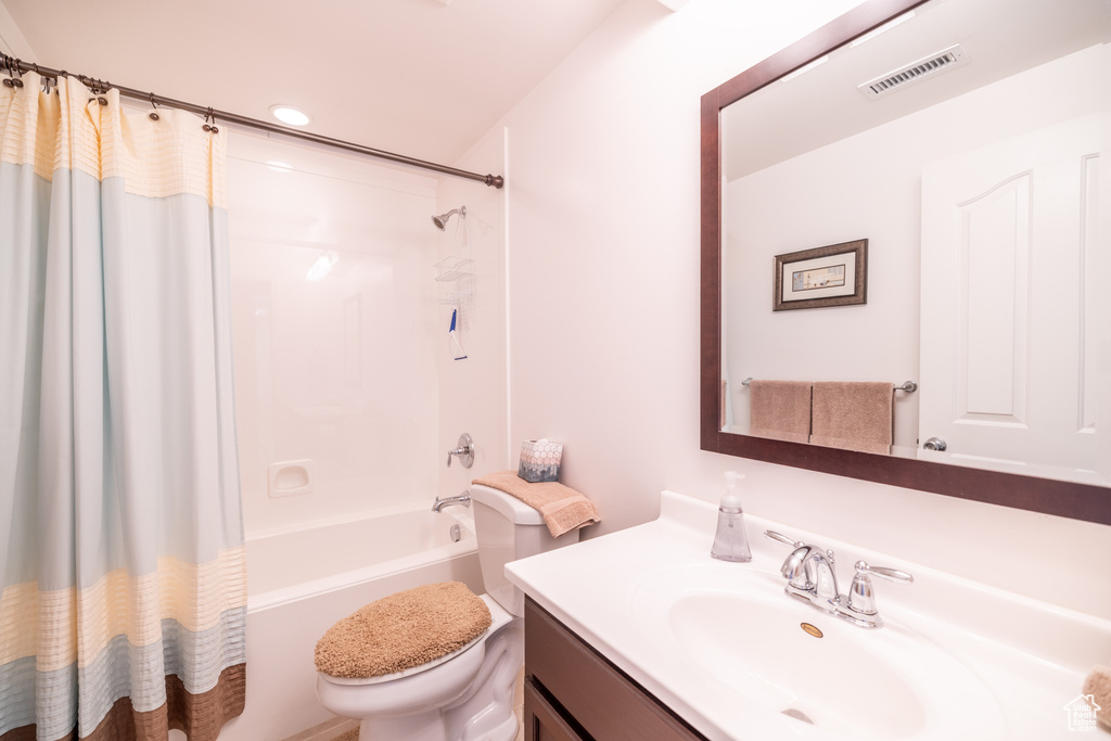 Full bathroom featuring vanity, shower / tub combo with curtain, and recessed lighting