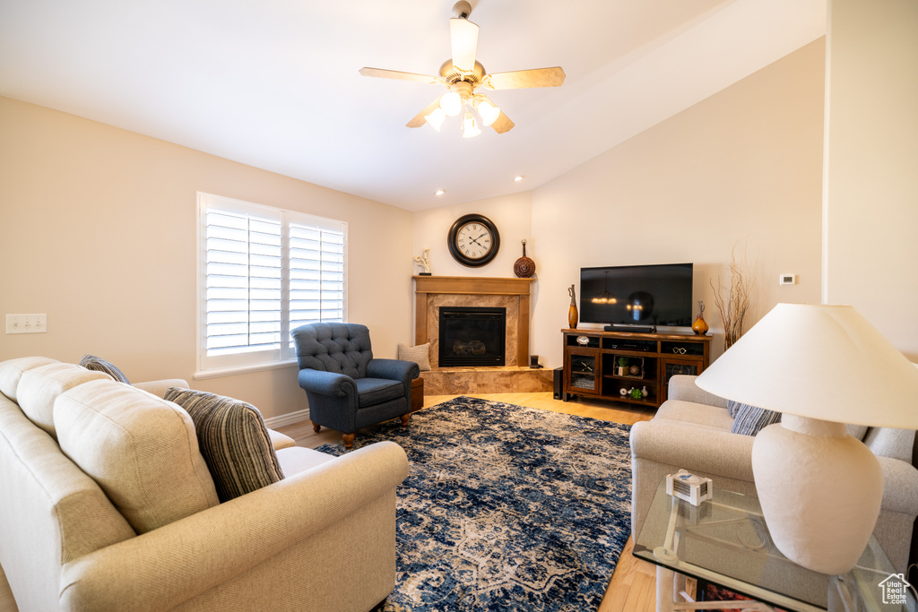 Living area with a fireplace, a ceiling fan, wood finished floors, lofted ceiling, and recessed lighting
