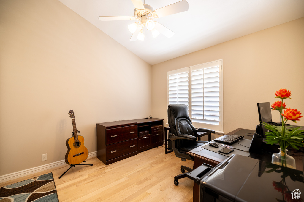 Office space with light wood-style flooring, ceiling fan, and lofted ceiling