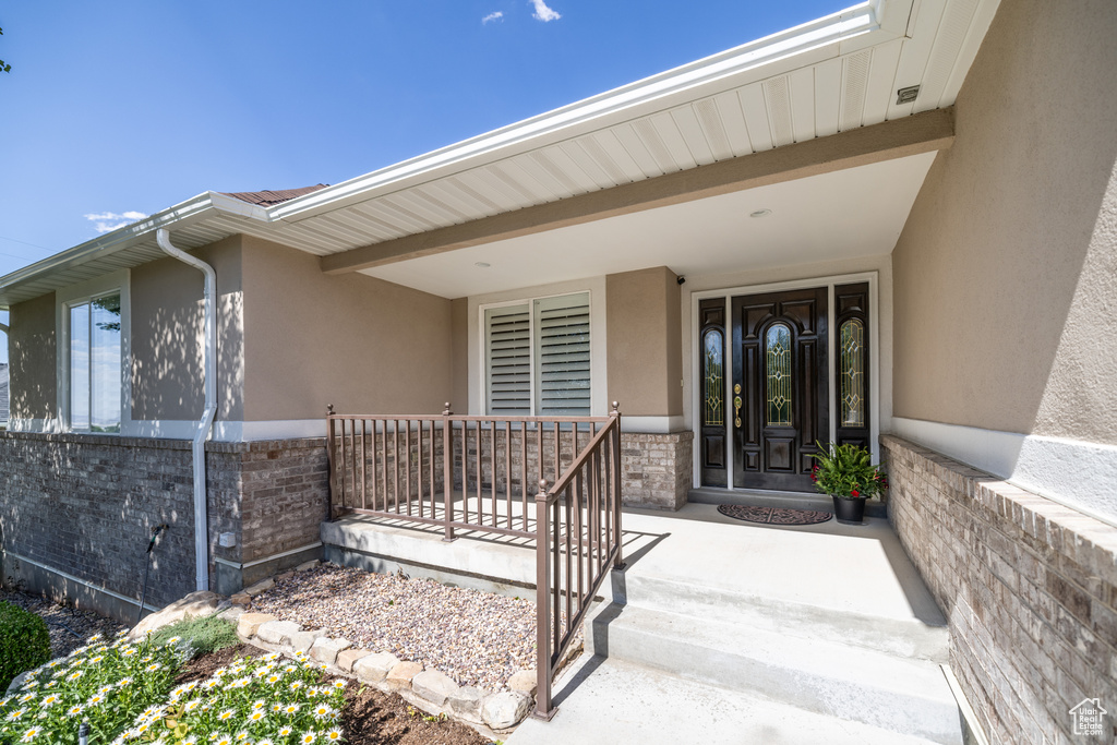 Property entrance featuring a porch and stucco siding