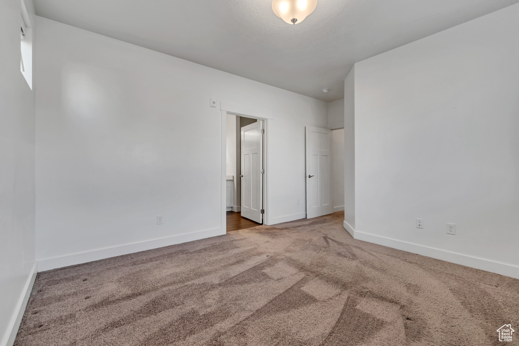 Carpeted empty room with baseboards