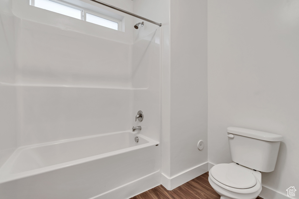 Full bath with wood finished floors and shower / bath combination