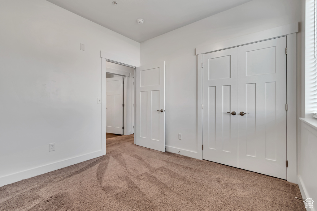 Unfurnished bedroom with carpet and a closet