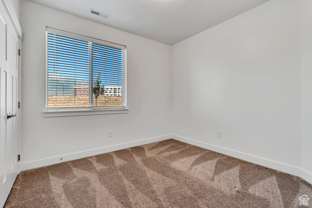 Empty room featuring carpet and baseboards