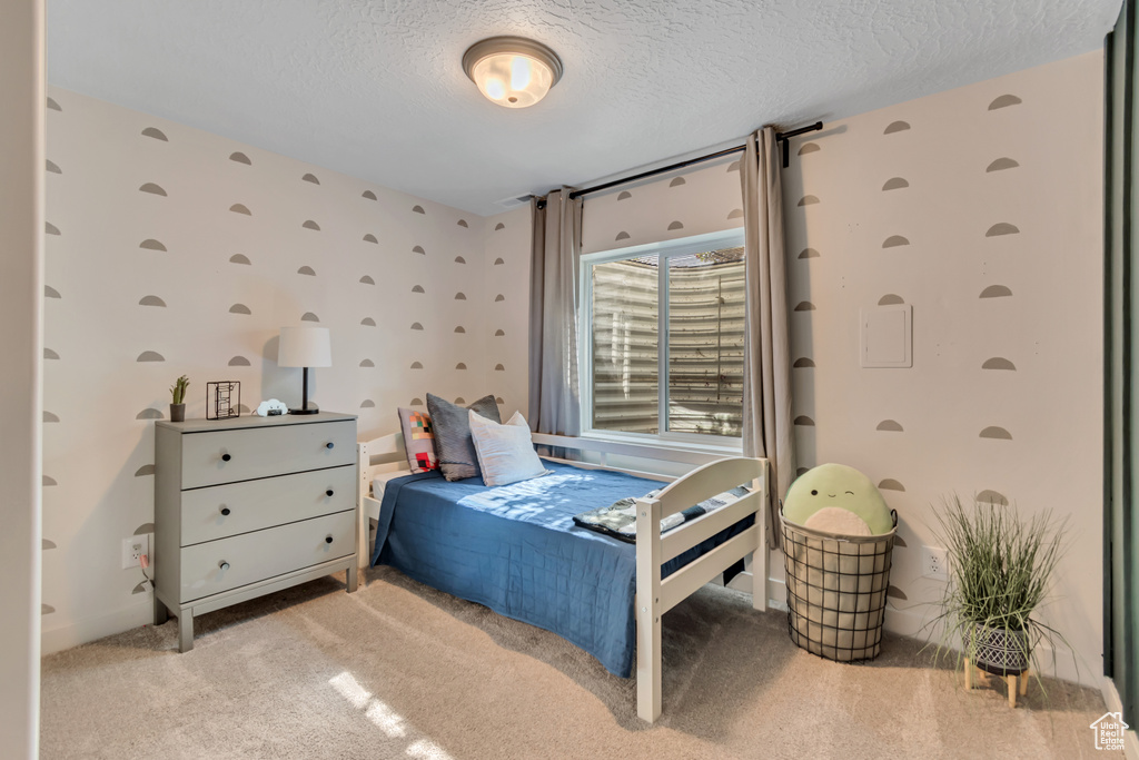 Carpeted bedroom featuring a textured ceiling