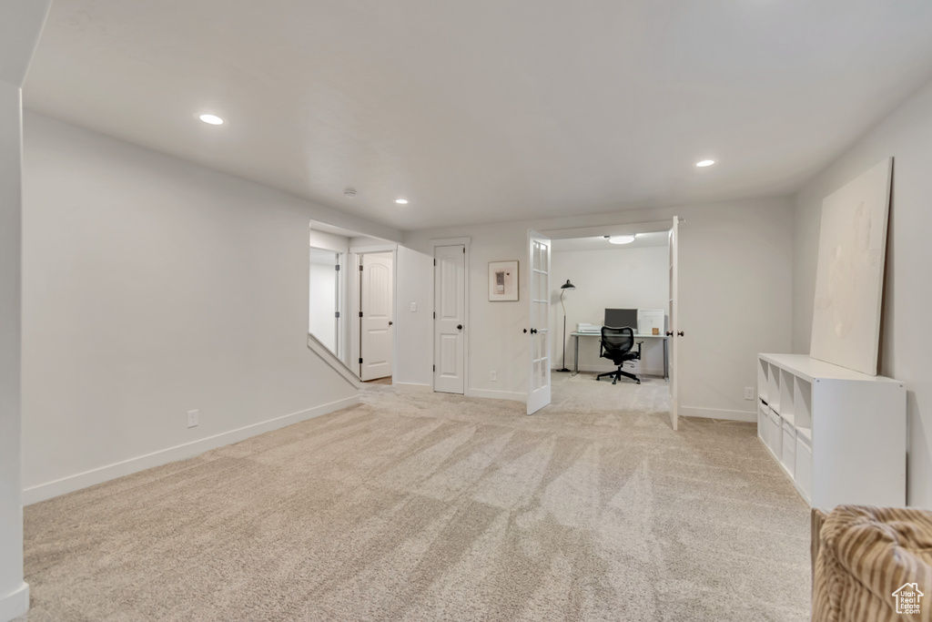 Unfurnished living room featuring recessed lighting, light carpet, and an office area
