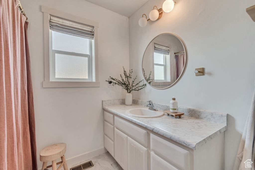 Full bathroom featuring marble finish flooring, vanity, and a shower with shower curtain