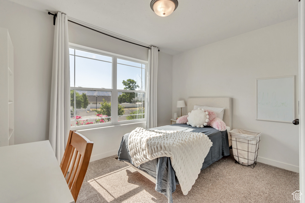 Bedroom featuring light colored carpet and baseboards